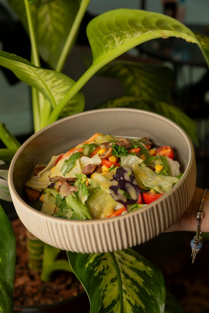 A colorful fresh vegetable salad served in a ceramic bowl, captured with natural lighting.